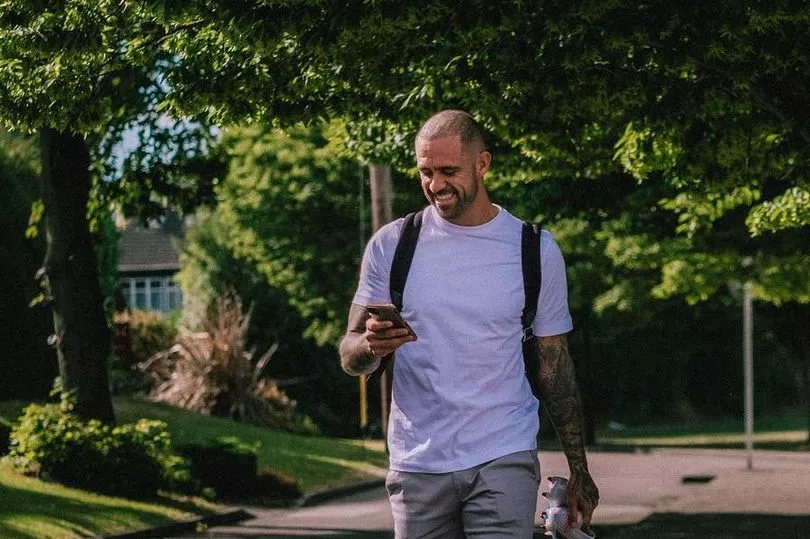 Danny Ings walking with phone