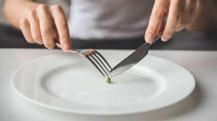 eating a single pea on a plate